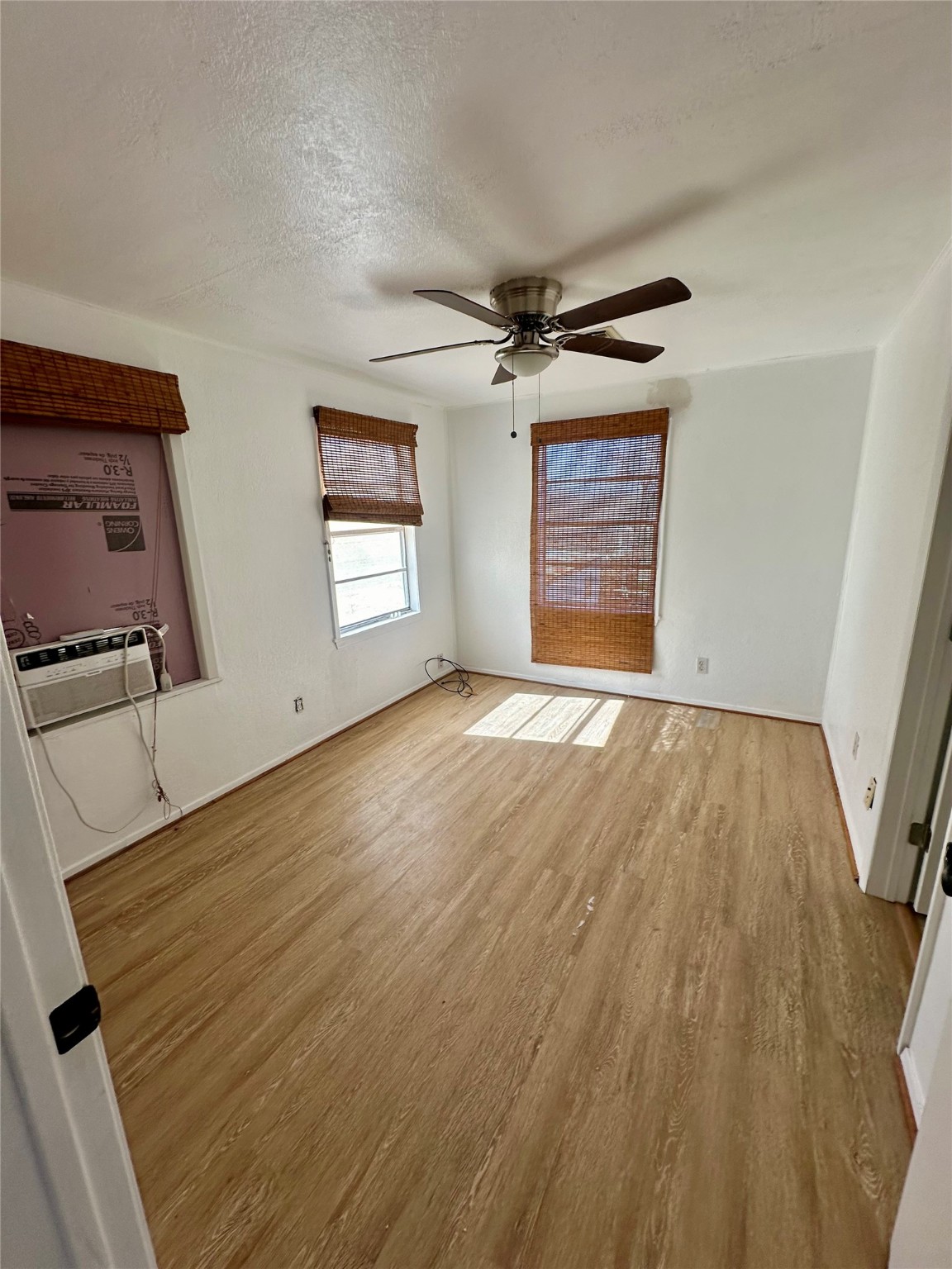 124 7th Street Dickinson, TX 77539 - Photo 12 of 19 a view of an empty room with wooden floor and a window
