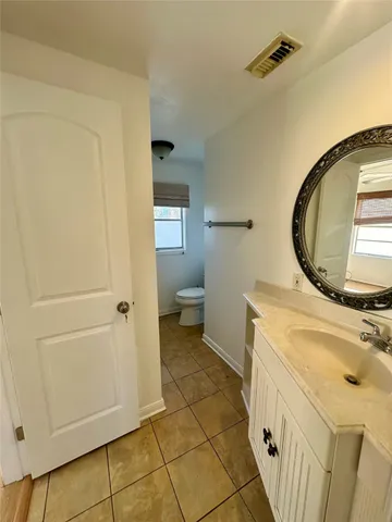 a bathroom with a sink a toilet and a mirror