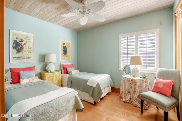 a bedroom with two beds and a chair