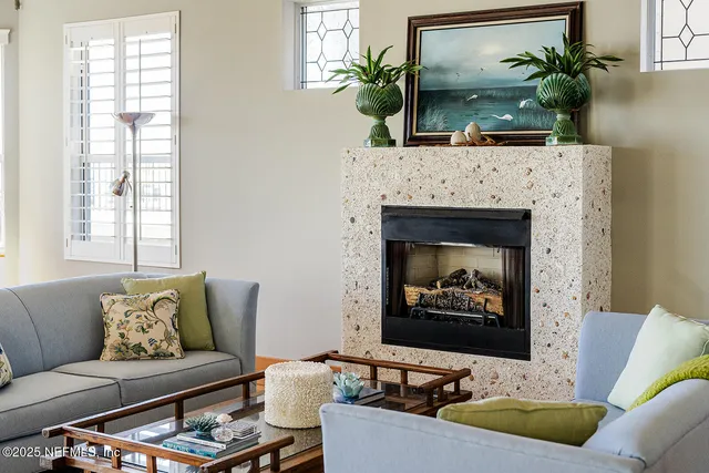 a living room with furniture a fireplace and a potted plant