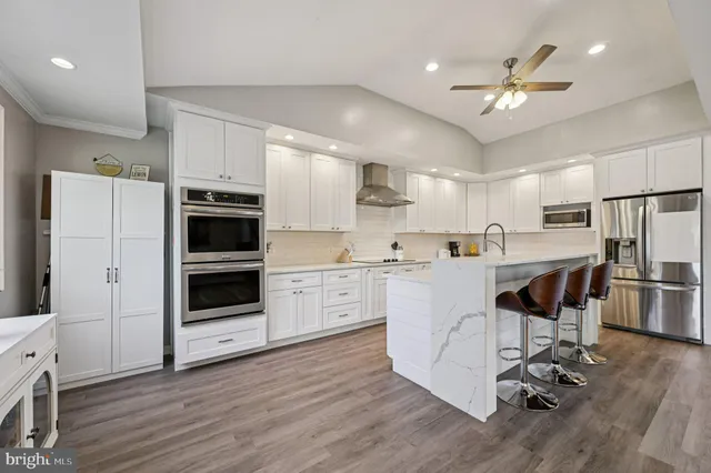 a kitchen with kitchen island white cabinets and stainless steel appliances