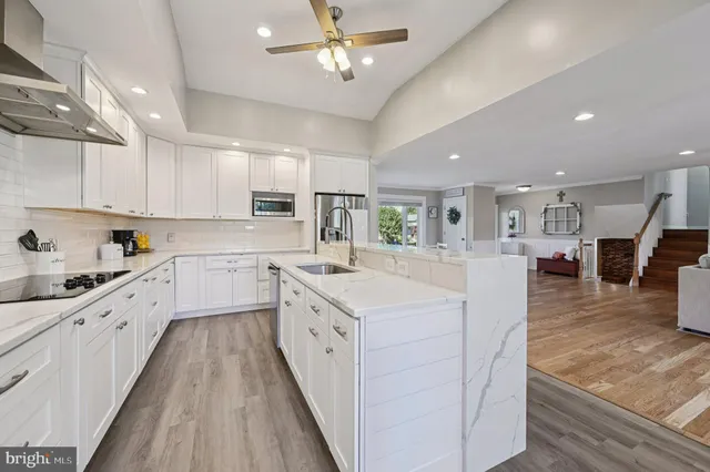 a large kitchen with stainless steel appliances kitchen island granite countertop a sink and cabinets