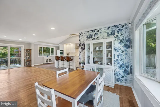 a living room with furniture a large window and wooden floor