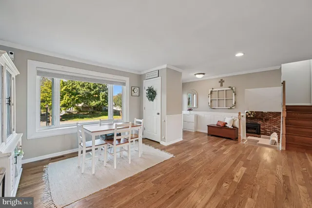a living room with furniture a large window and wooden floor