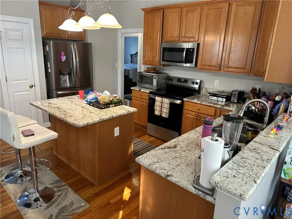 a kitchen with stainless steel appliances kitchen island granite countertop a sink dishwasher stove and cabinets