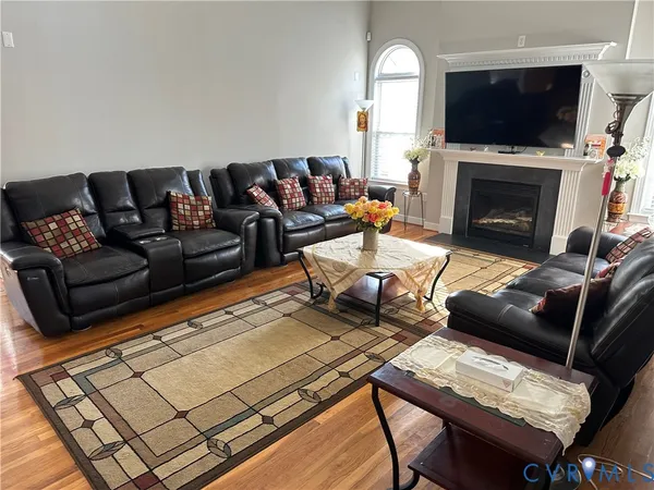 a living room with furniture a flat screen tv and a fireplace
