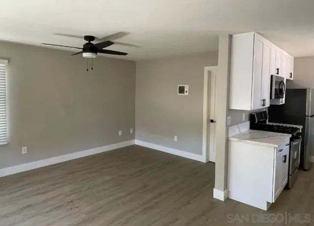 a view of a kitchen with a white cabinet and wooden floor