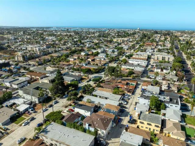 an aerial view of a city with lots of residential buildings and parking space