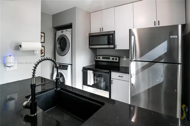 a kitchen with a refrigerator and a stove top oven