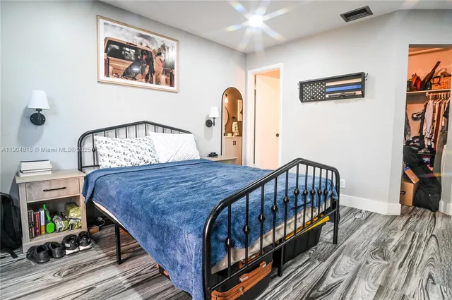 a bedroom with bed and wooden floor