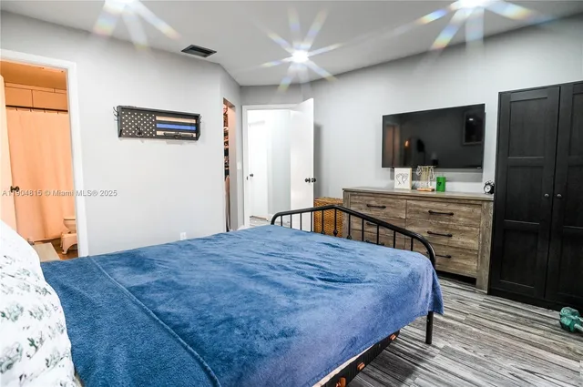 a bedroom with a bed and a flat screen tv