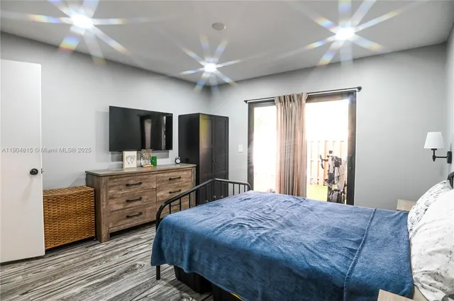 a spacious bedroom with a bed and a flat screen tv