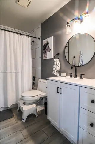a bathroom with a sink mirror vanity and toilet