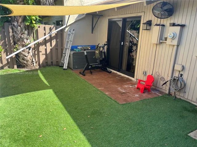 a view of a green field with trees in the background