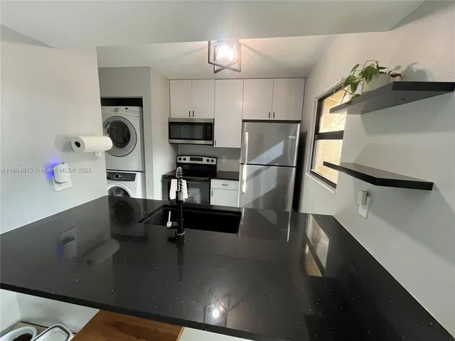 a kitchen with kitchen island stainless steel appliances a sink stove and refrigerator
