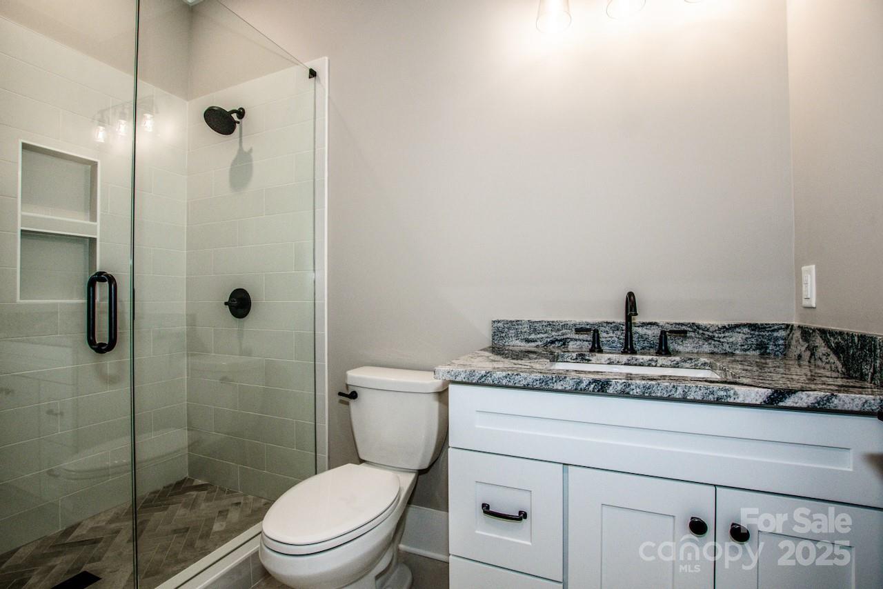 110 Emmaline Court Troutman, NC 28166 - Photo 9 of 40 a bathroom with a granite countertop sink a toilet and shower