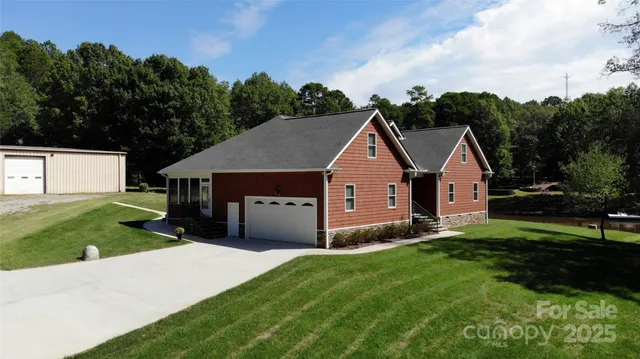 a aerial view of a house next to a big yard and large trees