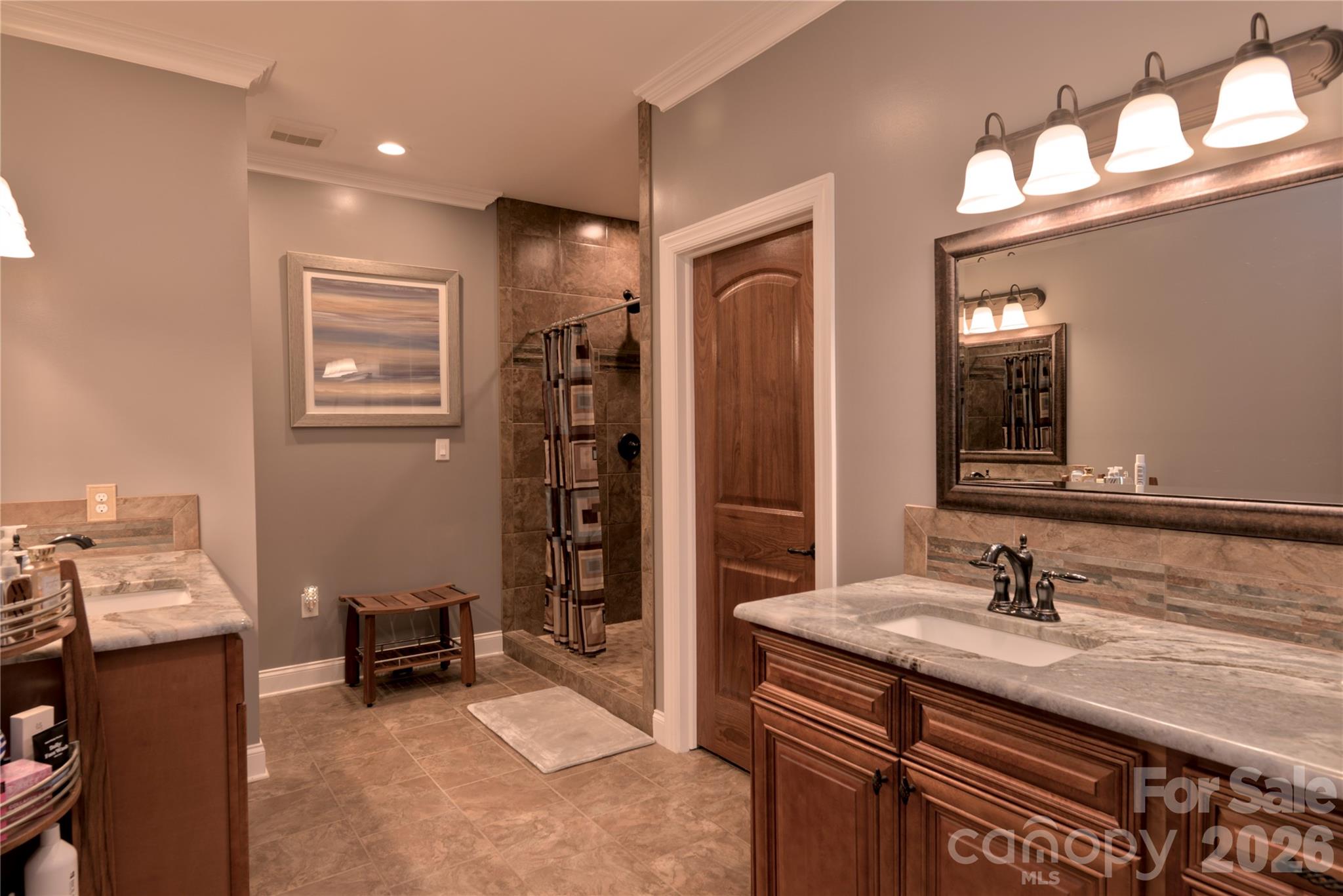 15027 Beatties Ford Road Huntersville, NC 28078 - Photo 22 of 33 a en suite bathroom with a sink double vanity and a mirror