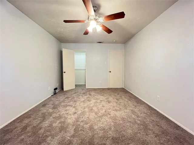 an empty room with chandelier fan