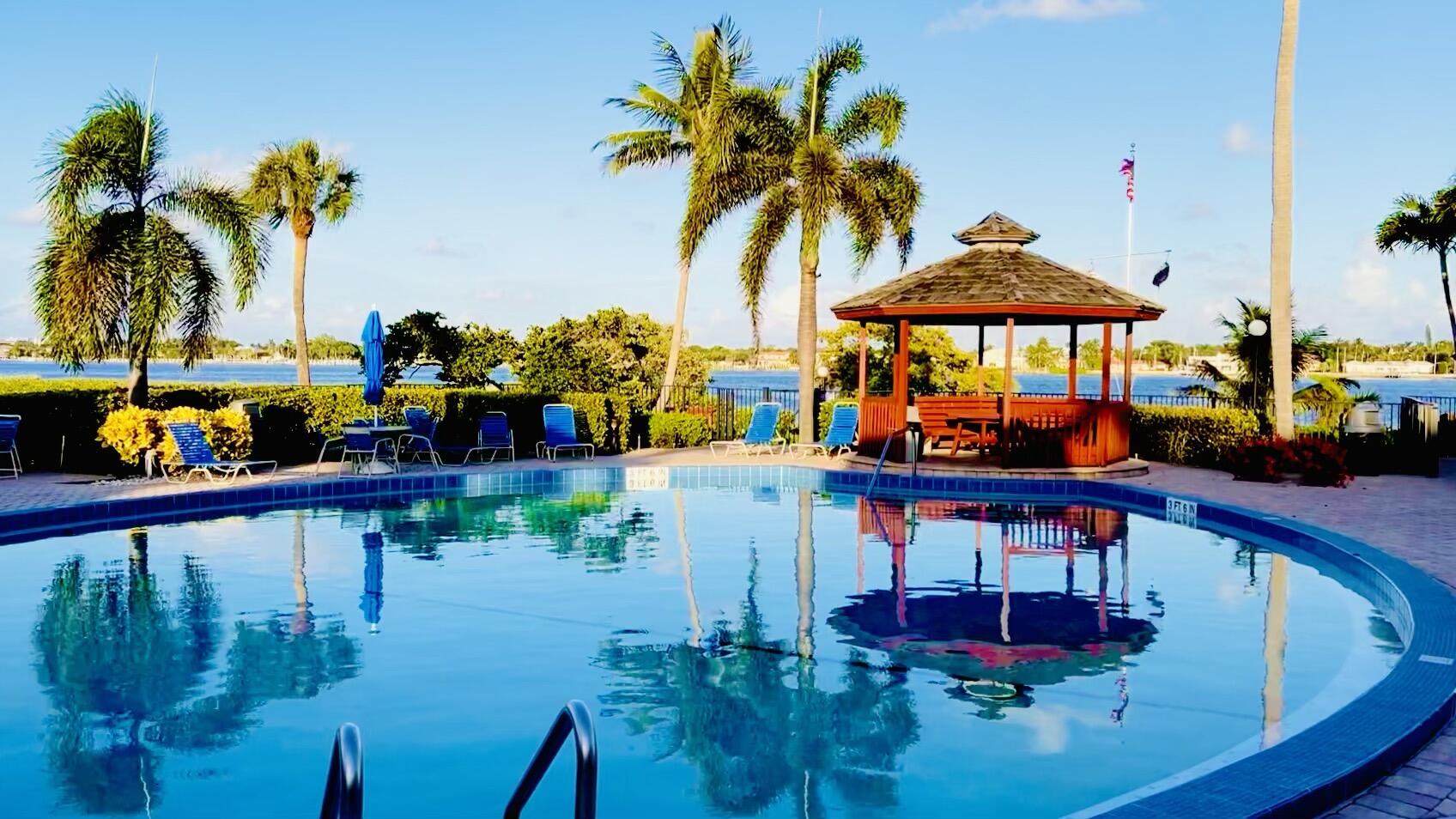 7030 Half Moon Circle, Unit 121 Hypoluxo, FL 33462 - Photo 13 of 74 a view of swimming pool with a table and chairs