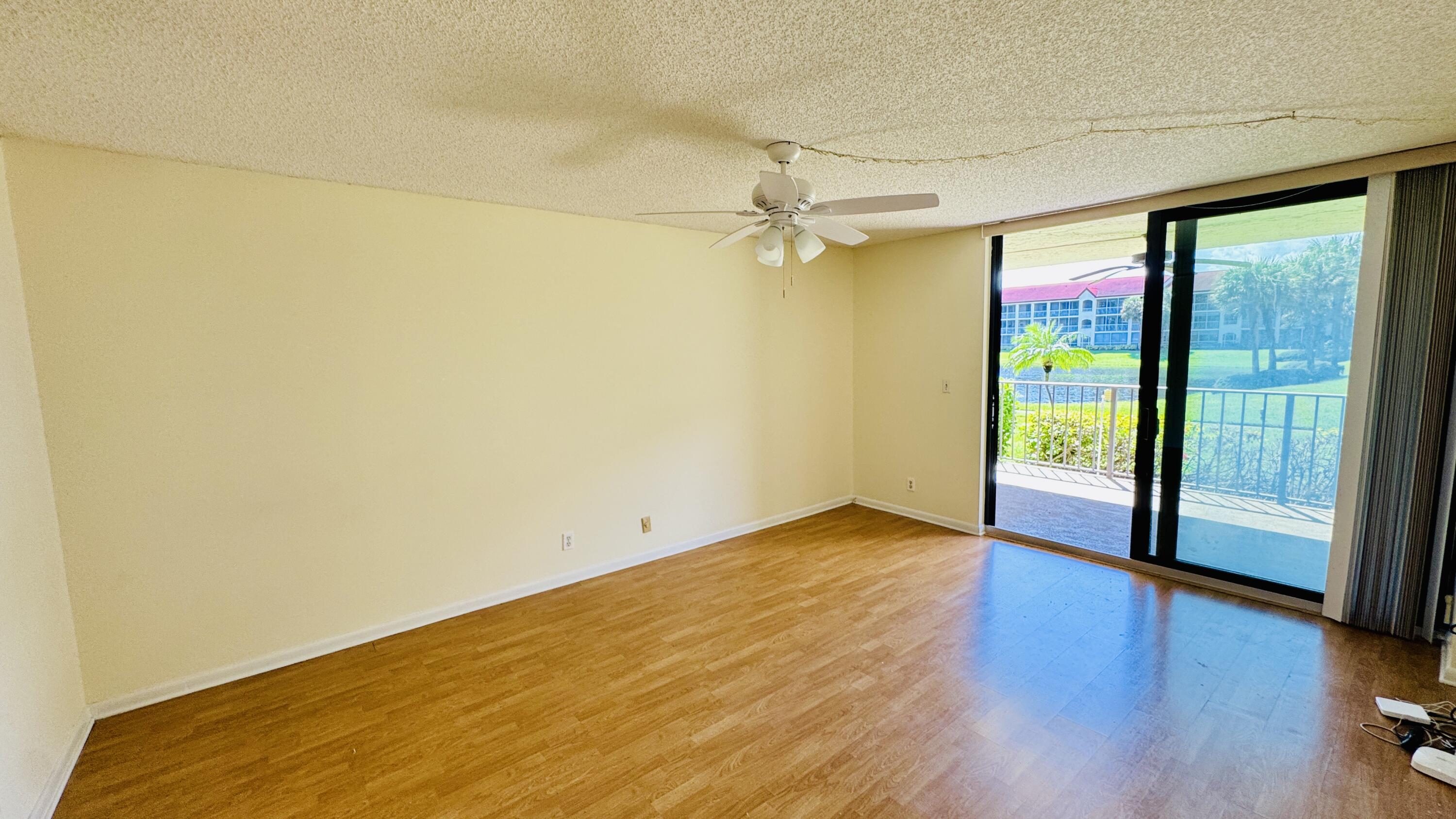 7030 Half Moon Circle, Unit 121 Hypoluxo, FL 33462 - Photo 32 of 74 wooden floor in an empty room with a window