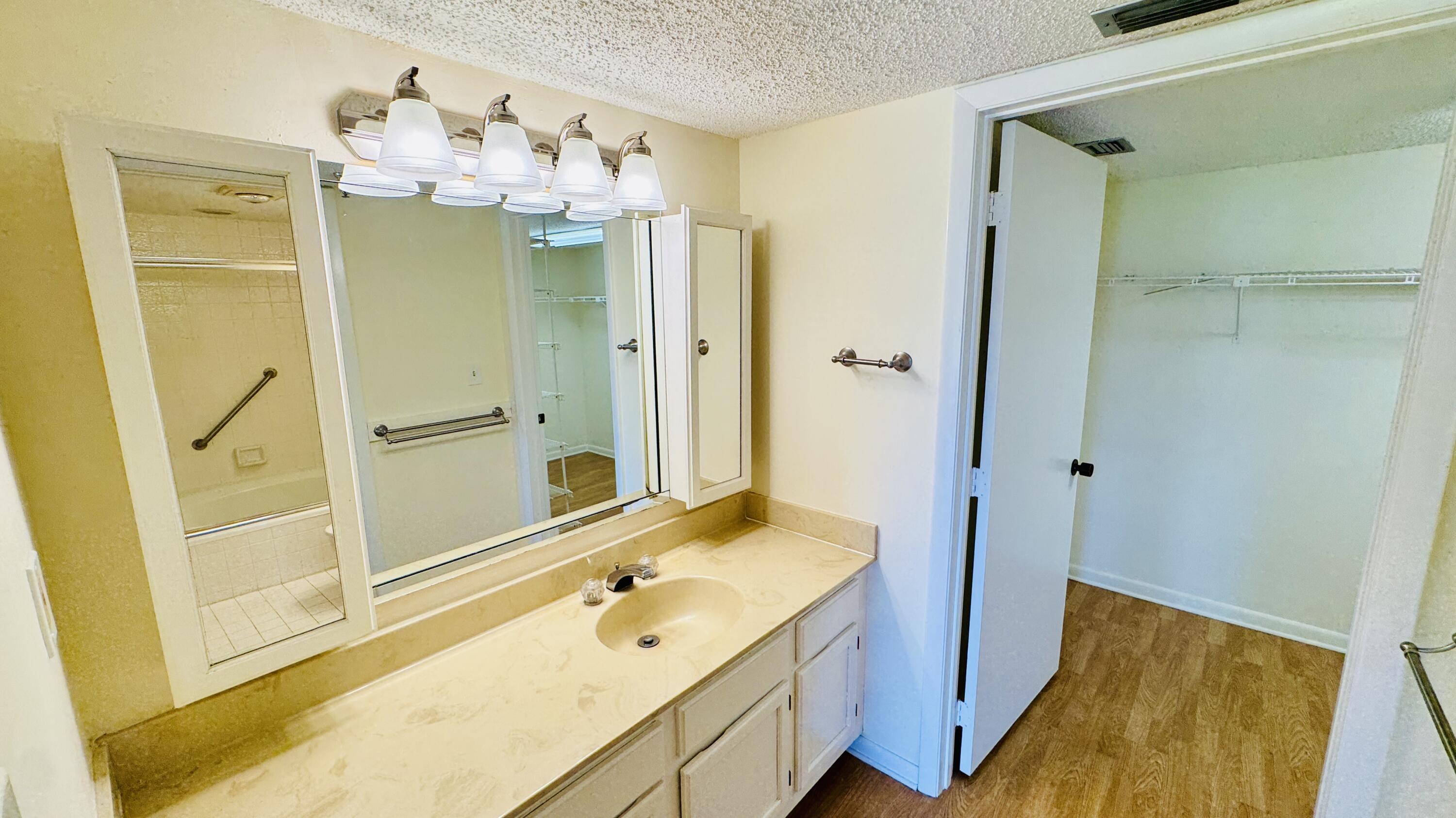 7030 Half Moon Circle, Unit 121 Hypoluxo, FL 33462 - Photo 35 of 74 a bathroom with a double vanity sink mirror and shower