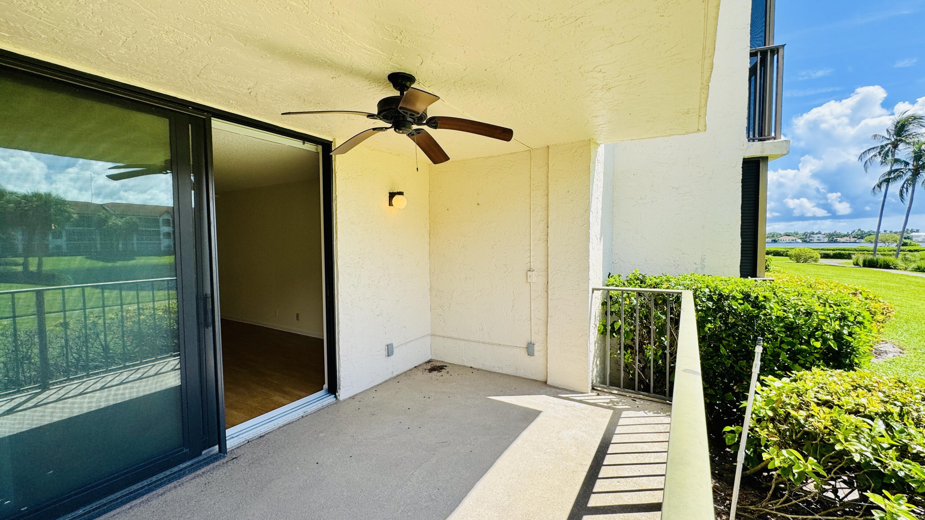 7030 Half Moon Circle, Unit 121 Hypoluxo, FL 33462 - Photo 39 of 74 a view of a porch with a floor to ceiling windows and yard