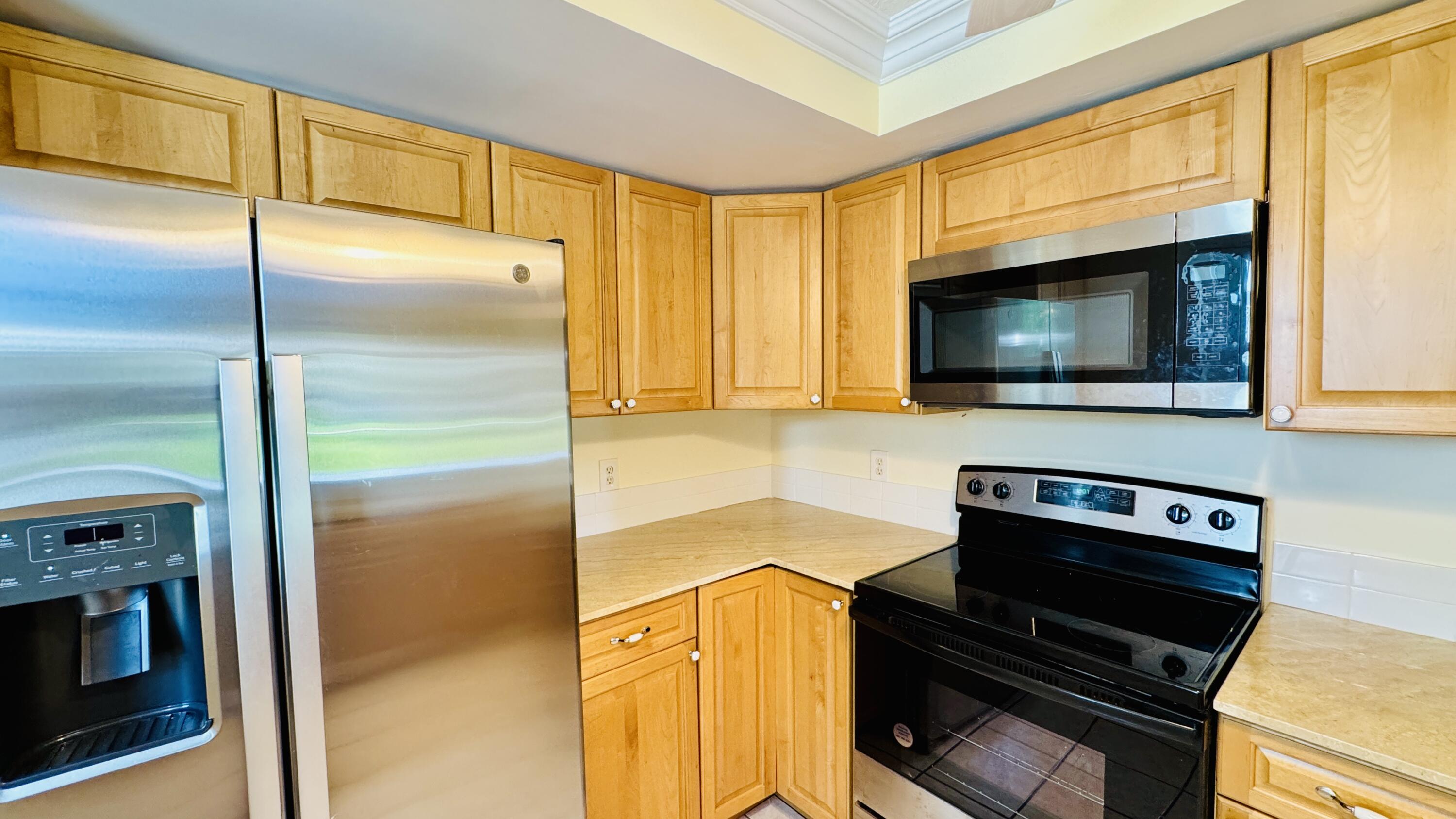 7030 Half Moon Circle, Unit 121 Hypoluxo, FL 33462 - Photo 45 of 74 a kitchen with a stove and a microwave