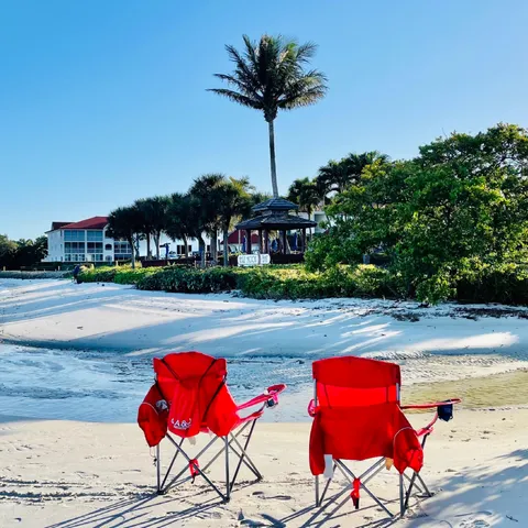 a view of a swimming pool with lawn chairs under an umbrella