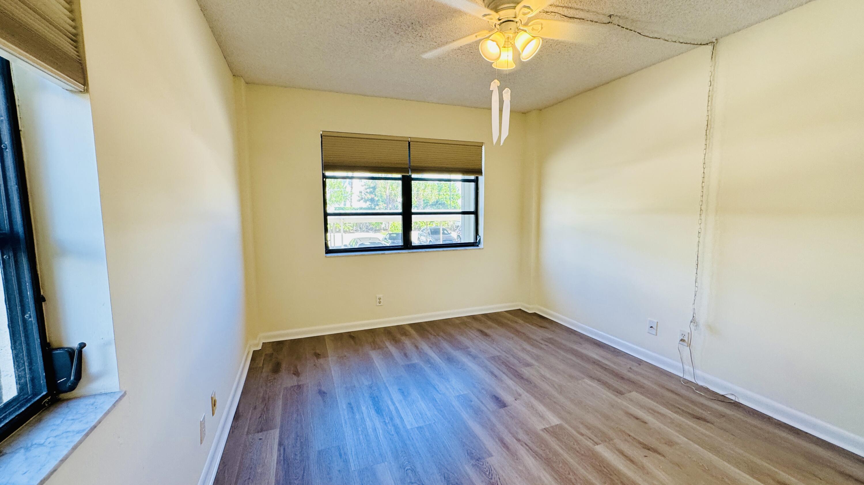 7030 Half Moon Circle, Unit 121 Hypoluxo, FL 33462 - Photo 53 of 74 wooden floor in an empty room with a window