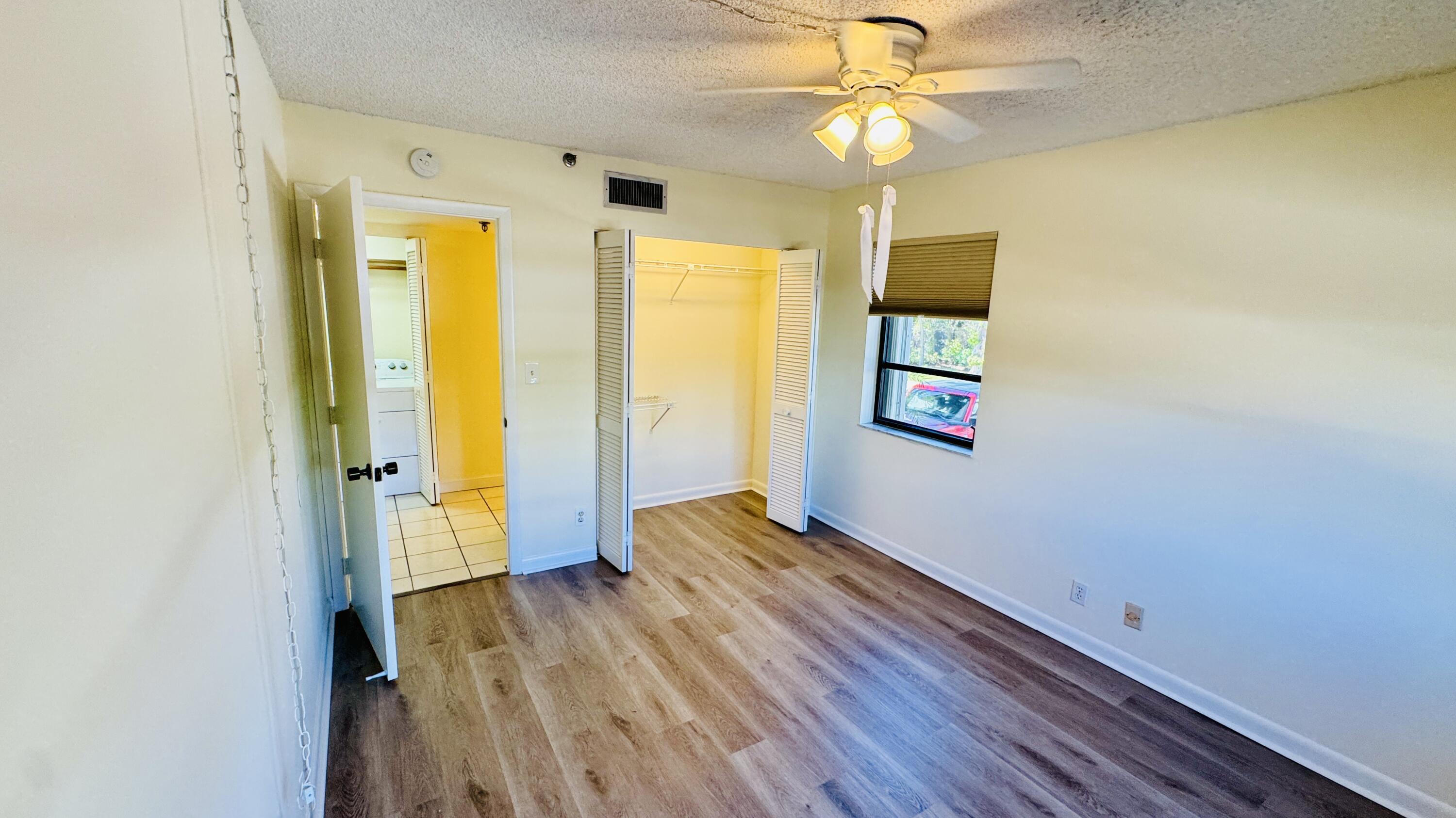 7030 Half Moon Circle, Unit 121 Hypoluxo, FL 33462 - Photo 54 of 74 wooden floor in an empty room with a window