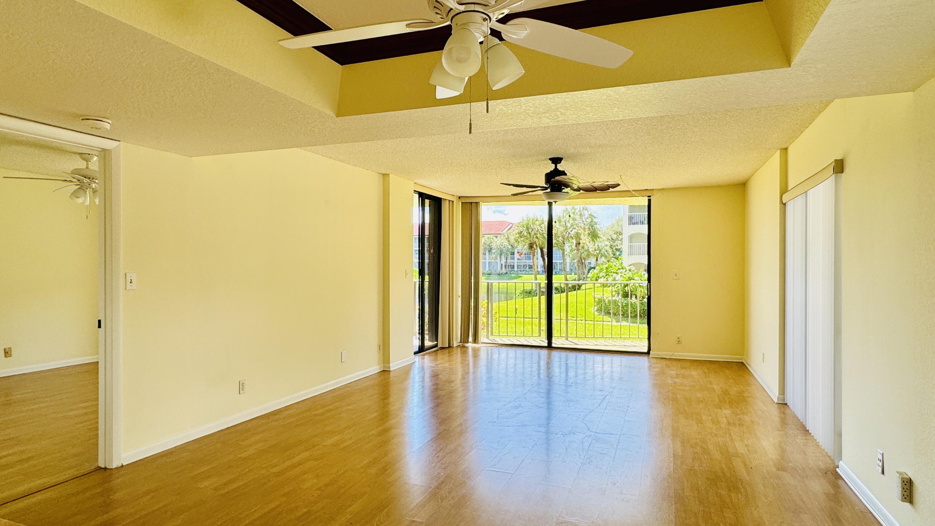 7030 Half Moon Circle, Unit 121 Hypoluxo, FL 33462 - Photo 62 of 74 a view of an empty room with wooden floor and a window