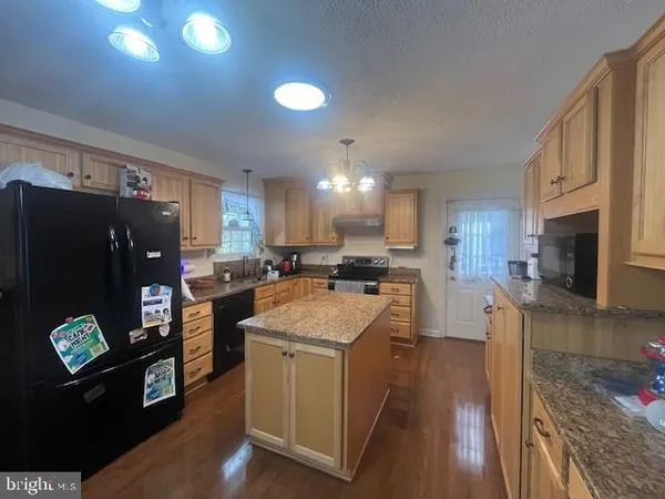 a kitchen with cabinets and wooden floor