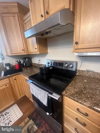 a kitchen with granite countertop a stove and a sink
