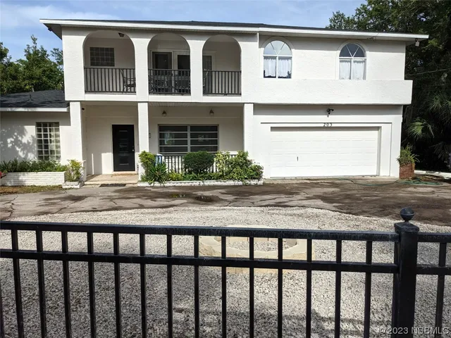 a view of a house with a balcony and tree