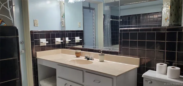 a bathroom with a sink mirror vanity and toilet