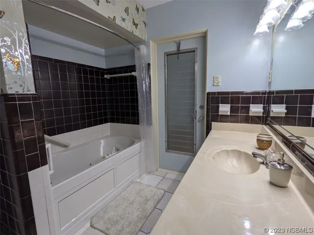 a bed sitting in a spacious bedroom next to a window