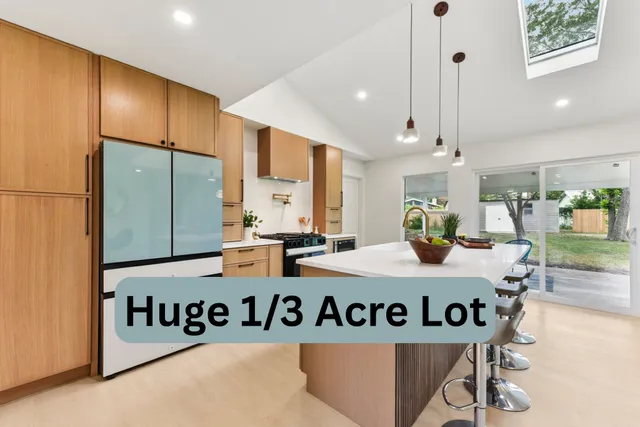 a kitchen with stainless steel appliances granite countertop a stove a sink and a refrigerator with wooden floor