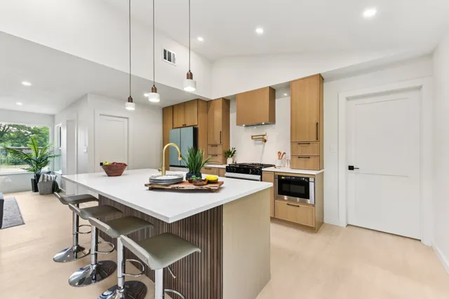 a kitchen with stainless steel appliances a sink stove and cabinets