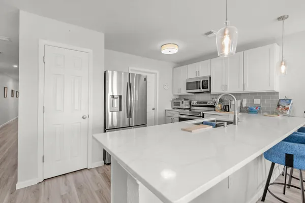a living room with furniture a large window and a dining table with wooden floor