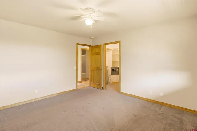an empty room with chandelier fan