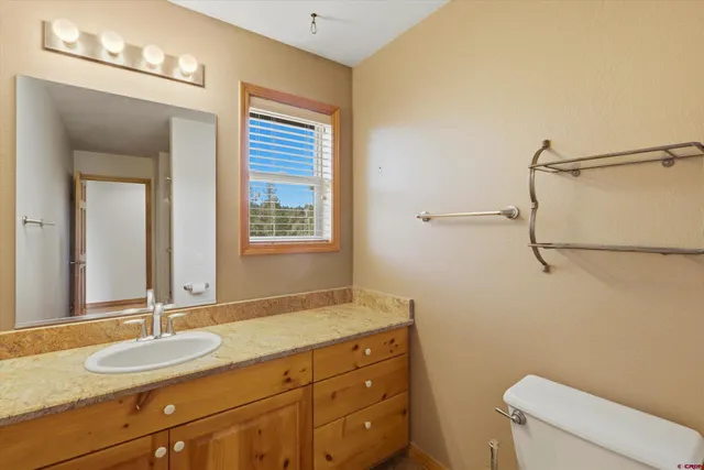 a bathroom with a granite countertop sink mirror vanity and toilet