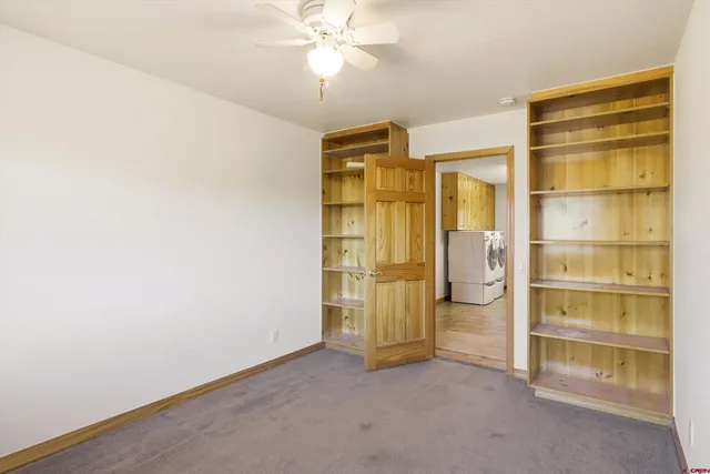 an empty room with a fireplace and cabinet