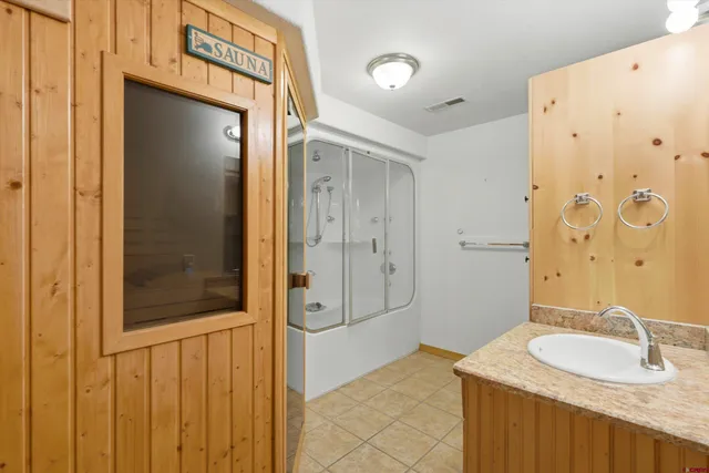 a bathroom with a granite countertop sink and shower