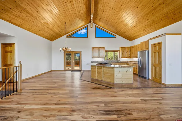 a view of a kitchen with wooden floor and a refrigerator