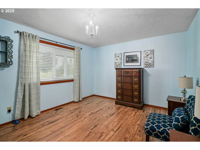 a view of an empty room with furniture and a window