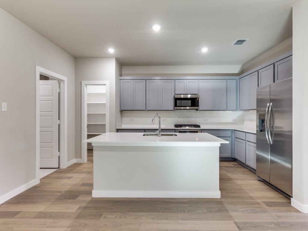 15224 Supreme Street Aledo, TX 76008 - Photo 8 of 25 a kitchen with stainless steel appliances granite countertop a stove and a refrigerator