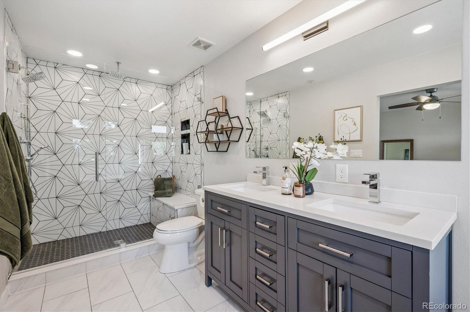 a spacious bathroom with a double vanity sink toilet and a mirror