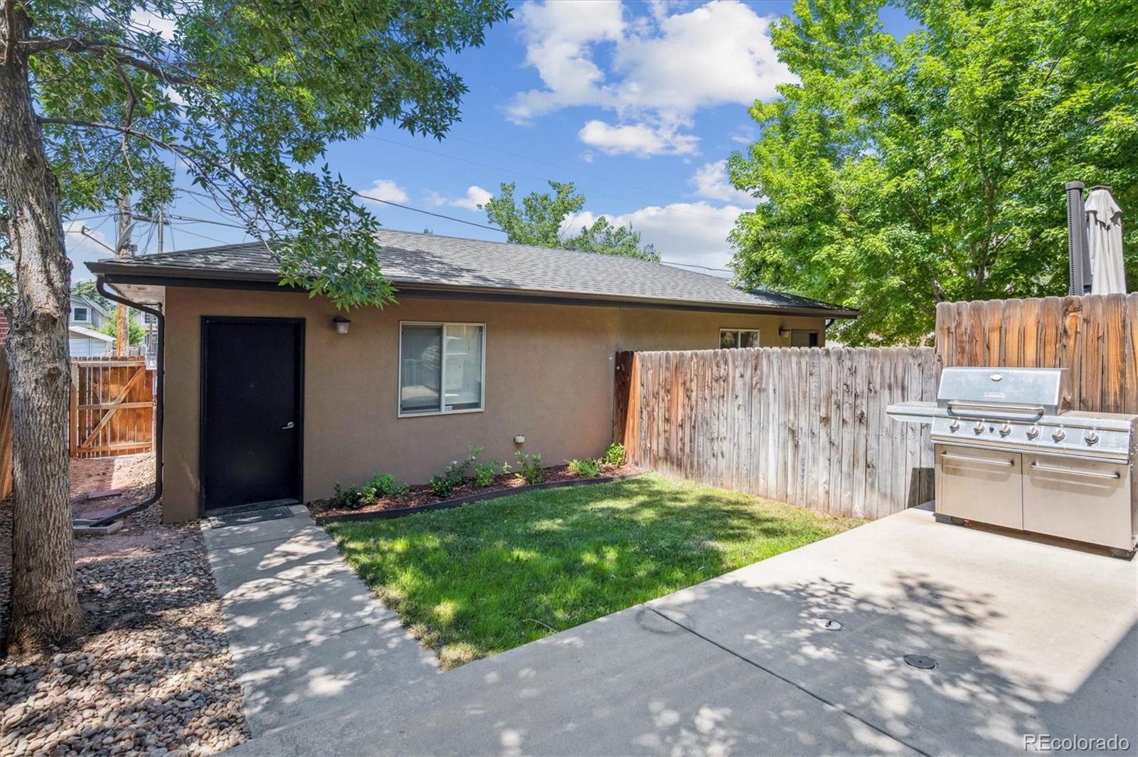 2157 South Logan Street Denver, CO 80210 - Photo 26 of 33 a backyard of a house with a small barn and wooden fence