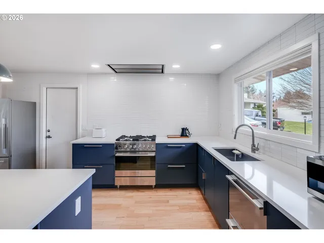 a kitchen with stainless steel appliances granite countertop a sink stove and refrigerator